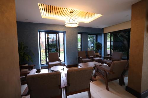 une salle d'attente avec des chaises, des tables et des fenêtres dans l'établissement PrideInn Westlands Luxury Boutique Hotel, à Nairobi