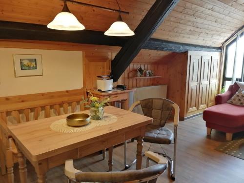 a dining room with a wooden table and chairs at Eifelferienwohnungen "Familie Saxler" in Bereborn