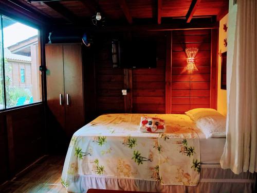 1 dormitorio con 1 cama en una habitación en Chalés praia do Rosa SC piscina comp, en Imbituba