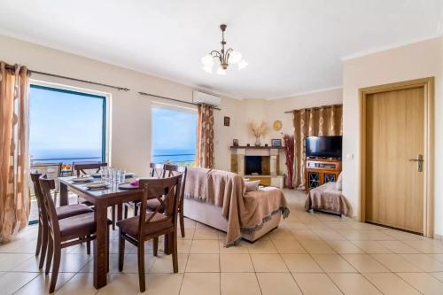- un salon avec une table à manger et une vue sur l'océan dans l'établissement Gkountis Apartments, à Tsoukaladhes