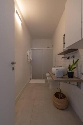 a white bathroom with a shower and a sink at Casa Violetta in Cagliari