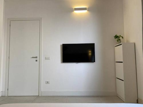 a room with a television on a white wall at Casa Violetta in Cagliari