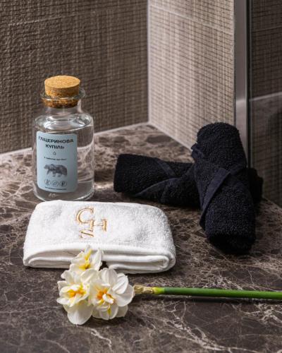 a towel and flowers on a counter in a bathroom at Crona SPA Karpaty in Skhidnitsa