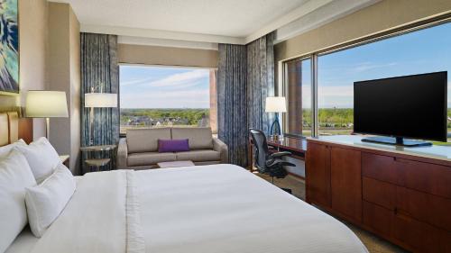 um quarto de hotel com uma cama e uma televisão de ecrã plano em The Westin Chicago Northwest em Itasca