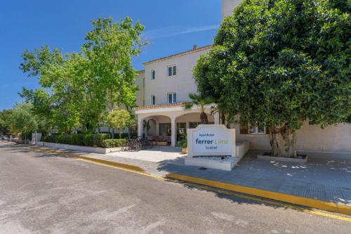 un edificio con un letrero al lado de una calle en Aparthotel Ferrer Lime Isabel en Cala Bona