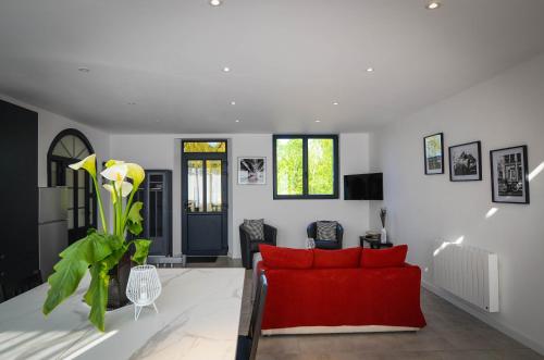 un salon avec un canapé rouge et une table dans l'établissement Le Quai Huppé, voie 2, à Noyelles-sur-Mer