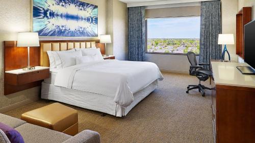 a hotel room with a large bed and a window at The Westin Chicago Northwest in Itasca