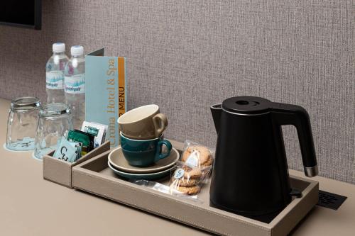 a tray with a tea kettle and cups on a table at Crona SPA Karpaty in Skhidnitsa
