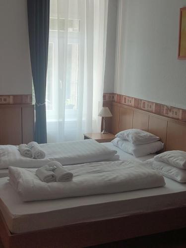 two beds in a bedroom with towels on them at Park Hotel in Nagyatád