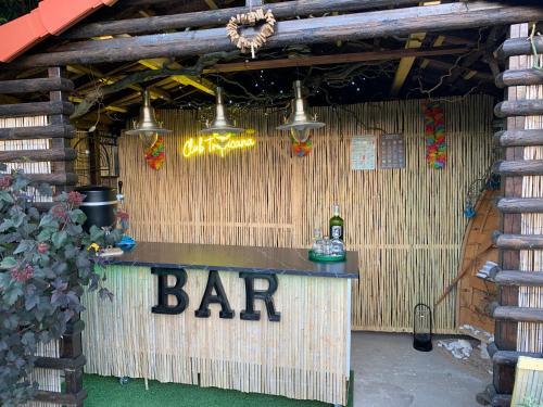 a bar in a bamboo building with a bar sign at Petit Luxe 