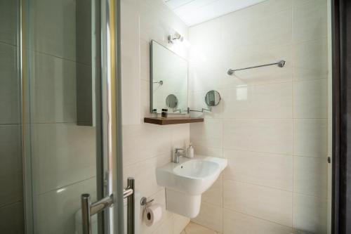 a white bathroom with a sink and a shower at Maria's Studios in Frangokastello