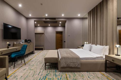 a bedroom with a bed and a desk and a television at Crona SPA Karpaty in Skhidnitsa