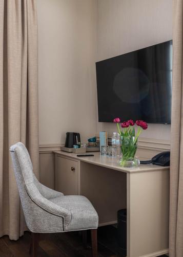 a room with a desk with a television and a chair at Crona SPA Karpaty in Skhidnitsa