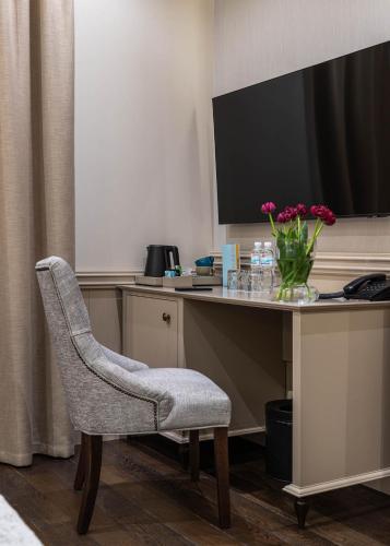 a desk with a chair and a vase of flowers at Crona SPA Karpaty in Skhidnitsa