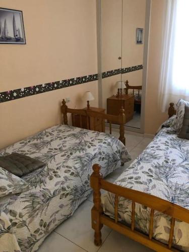 1 dormitorio con 2 camas y espejo en APARTAMENTO A 50 METROS DE LA PLAYA DE SILGAR, en Sanxenxo