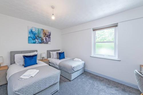 a bedroom with two beds and a couch and a window at St Pauls Square Holiday Home - Preston in Preston