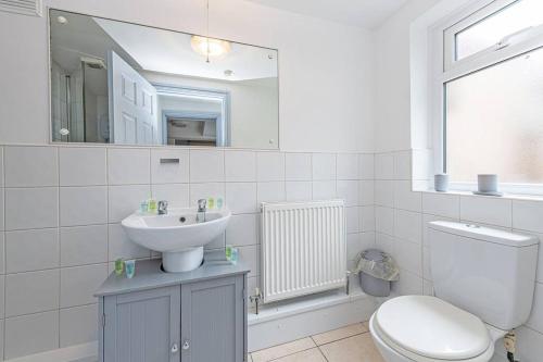 a white bathroom with a sink and a toilet at St Pauls Square Holiday Home - Preston in Preston