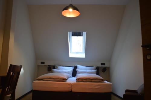 ein kleines Bett in einem Zimmer mit Fenster in der Unterkunft Schwemmers "Alter Stall" in Bad Windsheim