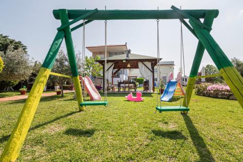 a swing set in a park with a gazebo at Frezia Complex - Frezia Apartments in Nea Potidaea