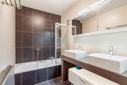 Baño con 2 lavabos y espejo en Luxury apartment with garden close to the beach en Ostende