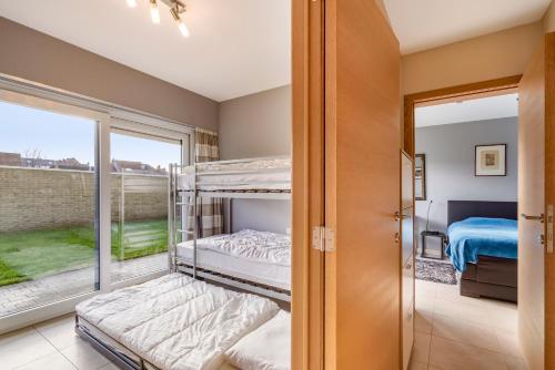 Pokój z 2 łóżkami piętrowymi i oknem w obiekcie Luxury apartment with garden close to the beach w Ostendzie