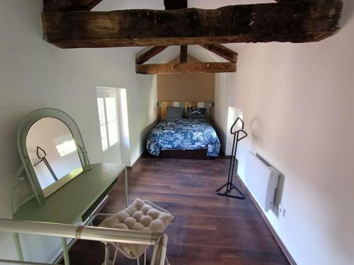 een slaapkamer met een bed, een tafel en een spiegel bij AU 2B 46 Ravissant duplex in Cahors