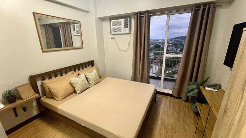 Habitación pequeña con cama y ventana en Verdon Parc Condo 1 Bedroom, en Davao City