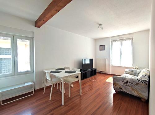 ein Wohnzimmer mit einem Tisch und einem Sofa in der Unterkunft #Lesgourmandises in Mulhouse
