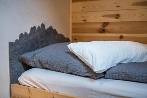 a bed with two pillows on top of it at Valentin36 Apartment Ritten in Funes