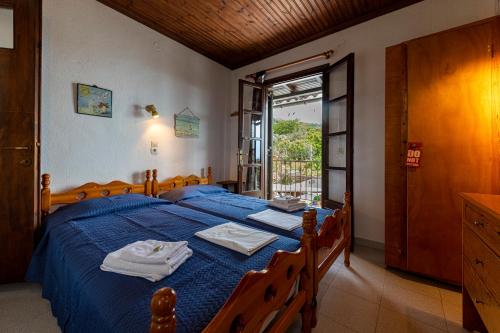 a bedroom with a blue bed with towels on it at SunRiseStudiosPapanero in Damouchari