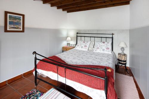 a bedroom with a bed with a black metal frame at Paradise House Furnas in Furnas
