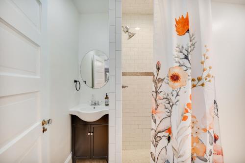 baño con lavabo y cortina de ducha con flores en Elizabeth City Vacation Rental Gazebo with Hot Tub!, en Elizabeth City