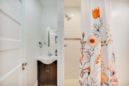 La salle de bains est pourvue d'un lavabo et d'un rideau de douche avec des fleurs. dans l'établissement Elizabeth City Vacation Rental Gazebo with Hot Tub!, à Elizabeth City