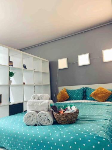 ein Schlafzimmer mit einem Bett mit Handtüchern und einem Korb mit Handtüchern in der Unterkunft Cozy Studio in Cluj-Napoca in Cluj-Napoca