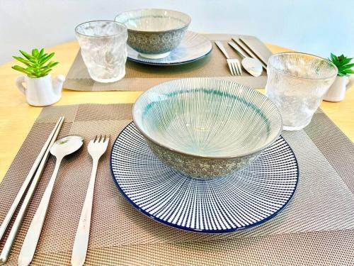 a table with two plates and a bowl on a table at P 1-5Pax Cozy Home Setia Alam Trefoil Smrt TV&Wifi in Setia Alam
