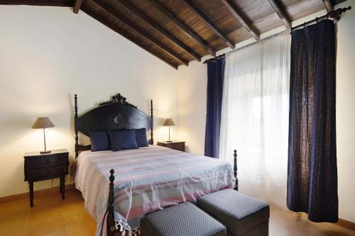 a bedroom with a large bed and a window at Vila Nova House in Laseira