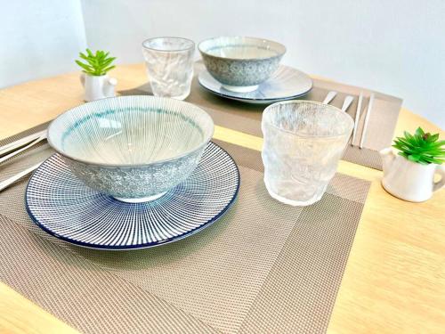 a table with bowls and plates and glasses on it at P 1-5Pax Cozy Home Setia Alam Trefoil Smrt TV&Wifi in Setia Alam