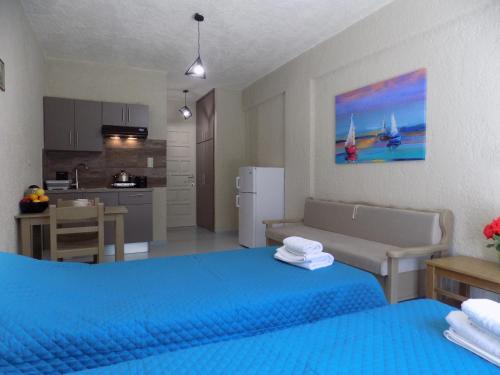 a bedroom with a blue bed and a kitchen at Afrodite Spacious Apartments! in Agia Effimia