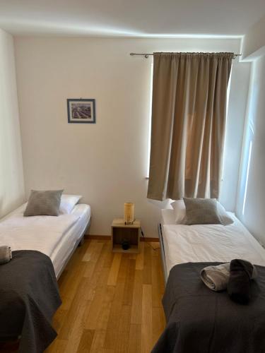 a room with two beds and a window at Apartment David in Biograd na Moru