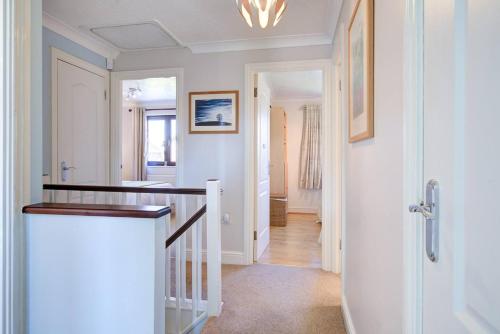 a hallway with white walls and a staircase in a home at Beautiful house in Thorpe Bay in Southend-on-Sea