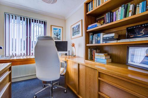 an office with a desk and a chair and books at Serene Family Escape - Spacious, Near Thorpe Bay and Southend, Beaches & Amenities - Pass the Keys in Southend-on-Sea