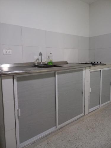 uma cozinha com armários de aço inoxidável e um lavatório em Hostal Don Ramón em Valledupar