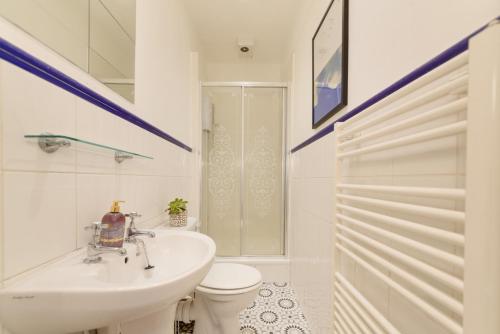 ein weißes Bad mit einem Waschbecken und einem WC in der Unterkunft Number7, 3 minutes to the Beach, Super King Beds, Part of Burlington-Escapes in Brighton & Hove