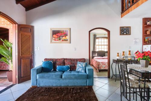 a living room with a blue couch and a table at Casa Carvalho in Paraty