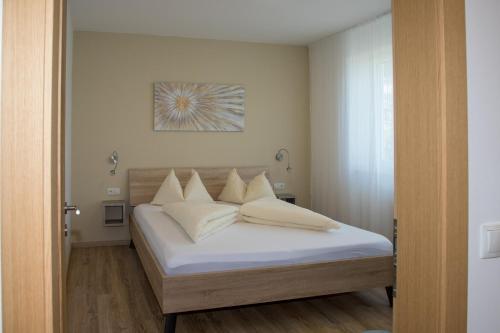 une chambre avec un lit avec des draps blancs et des oreillers dans l'établissement Appartement 7, à Caldaro