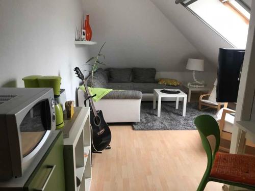 a living room with a couch and a guitar in it at Ferienwohnung Huehnergott in Dwasieden
