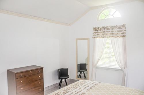 a bedroom with a bed and a dresser and a window at Bamboo Vacation Home in Lewis