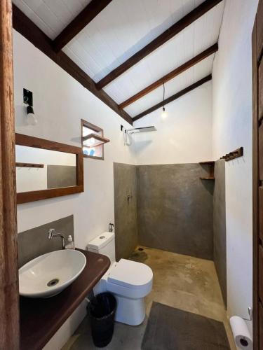 a bathroom with a white toilet and a sink at Casa deck Caraíva in Caraíva