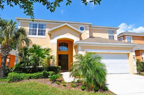 a house with palm trees in front of it at Tiger Lilly at Ellis Exclusive Villas in Kissimmee