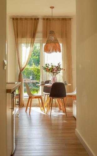 a dining room with a table and chairs and a window at Costaserenasuites in Nigrán